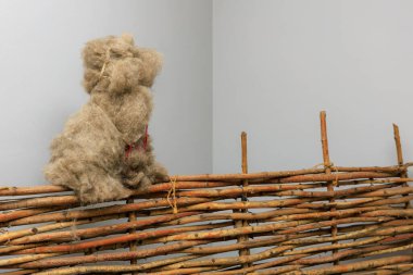 Dekoratif bir kırsal çitte köpek şeklinde toplanan yün. Seçici odaklı arkaplan ve metin için alanı kopyala