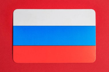 Kırmızı arkaplanda Rus bayrağı ulusal kimliği simgeliyor.