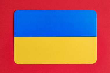 Ukrainian flag on vibrant red background representing national colors and identity. clipart