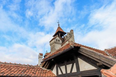 Kırmızı çatılı ve saat kulesi olan bir bina. 16 Aralık 2024 Bran Romanya.