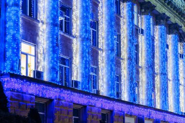 Mimari görünüş geceleri mavi ve beyaz festival ışıklarıyla süslenir. 20 Aralık 2024 Balti Moldova.