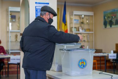Yaşlı beyaz erkek oy kullanma merkezindeki seçimlerde oy kullanıyor. 21 Kasım 2021 Balti, Moldova.