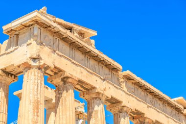 Bina sütunları ve çatısı olan bir tapınak. Sütunlar taştan ve çatı da ahşaptan yapılmıştır. Bina, Atina 'nın Akropolis kentinde güneşli bir bölgede yer alıyor.