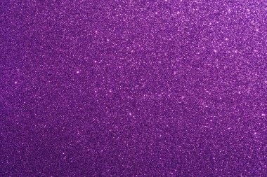 Pırıl pırıl parlayan mor bir arka plan. Parıltı tüm arka plana saçılmış.