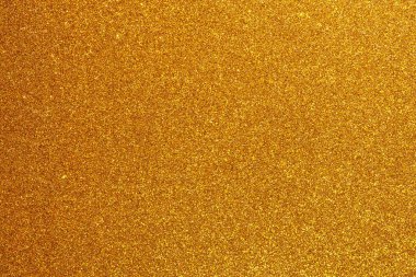 Bir sürü küçük altın noktalı altın bir arka plan. Arka plan çok parlak ve noktalar çok küçük.