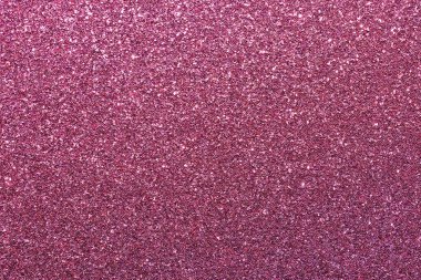 Pembe bir arka plan ve parlak bir doku. Arka plan pembe ve simler de pembe. Işıltı arka fonun her tarafına saçılmış. Parlak ve parlak bir görüntü veriyor.