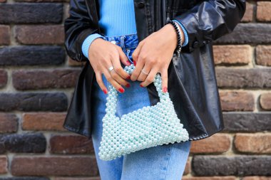 Genç bir bayanın elinde şık bir çanta. Seçici odaklı arkaplan ve metin için alanı kopyala