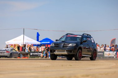 Siyah bir araba, bir kalabalık tarafından izlenen bir pistte gidiyor. 2 Temmuz 2023 Liadoveni Moldova