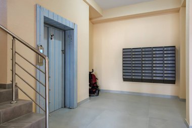 Asansörü, posta kutuları, merdivenleri ve kırmızı mobiletli mobiletiyle modern apartman koridoru. 29 Eylül 2023 Balti Moldova.
