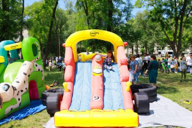 Çocuk, açık hava etkinliğinde şişme kaydırağın keyfini çıkarıyor. 31 Mayıs 2024 Balti Moldova.