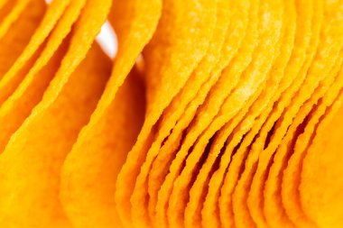 Bir yığın sarı cips. Fişler üst üste dizilmiş.