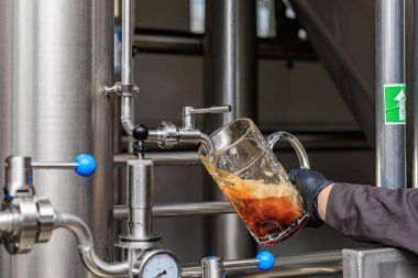 Bira fabrikasındaki paslanmaz çelikten akan yıllanmış bira..