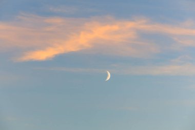 Hilal ay sakin günbatımı gökyüzünde yumuşak bulutlarla.