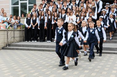 Okul seremonisinde çocuklar binanın önünde üniformalı bekliyor. 2 Eylül 2024 Balti Moldova.