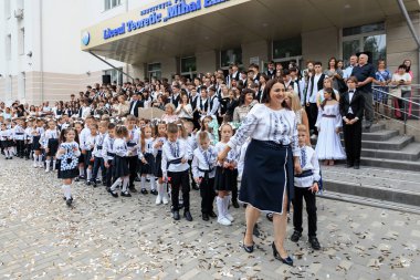 Çocuklar ve yetişkinler okul etkinliğini dışarıda geleneksel kıyafetleriyle kutluyorlar. 2 Eylül 2024 Balti Moldova.