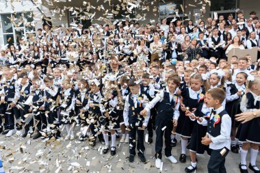 Genç beyaz çocuklar ve konfeti ile neşeli bir okul kutlaması. 2 Eylül 2024 Balti Moldova.