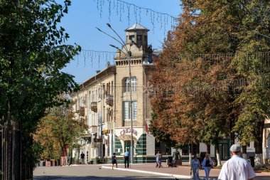 Sonbaharda tarihi mimarisi ve gezinen insanlarla şehir caddelerini büyülemek. 9 Eylül 2024 Balti, Moldova.