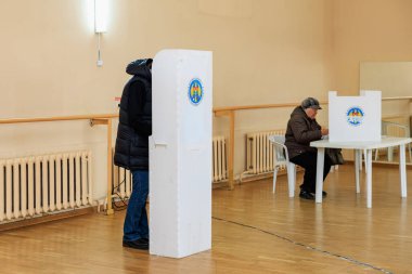 Kafkasyalı yetişkinler oy kullanma merkezinde oy sandıkları ve kulübelerle oy veriyorlar. 20 Ekim 2024 Balti, Moldova.