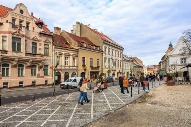 Kalabalık bir cadde, insanlar yürüyor ve arabalar sürüyor. Manzara hareketli ve hareketli. 14 Aralık 2024 Brasov Romanya