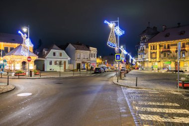 Geceleyin küçük bir kasabada Noel 'de yaya geçidi aydınlandı. Sokak boş ve ışıklar da açık. 13 Aralık 2024 Brasov Romanya