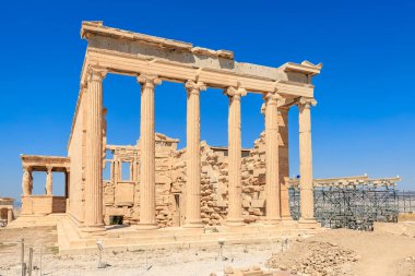 The building is a temple with columns and a large open doorway. The sky is blue and the sun is shining, Acropolis in Athens clipart