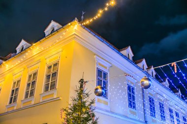 Üzerinde Noel ağacı ve çatısında ışıklar olan bir bina. Işıklar mavi ve beyaz