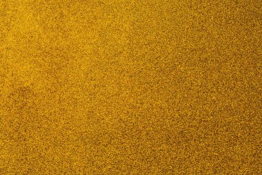 Bir sürü küçük sarı noktalı altın bir arka plan. Arka plan parlak ve noktalar her yere dağılmış.