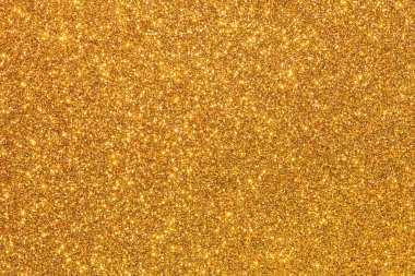 Işıltılı bir dokusu olan altın bir arkaplan. Altın rengi görüntünün her yerinde belirgin, parlak noktalar biraz ışıltı ve parıltı katıyor. Genel etki lükstür.