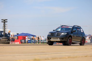 Siyah bir araba, bir kalabalık tarafından izlenen bir pistte gidiyor. Araba bir haber kanalı tarafından destekleniyor. 2 Temmuz 2023 Liadoveni Moldova