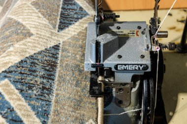 Endüstriyel dikiş makinesi kumaş rulosunda karmaşık geometrik desen dikiyor. 9 Ocak 2024 Balti, Moldova.