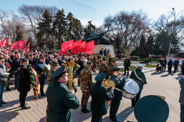 Pirinç bandosu ve şehir parkında kırmızı bayraklı askeri geçit töreni. 26 Mart 2024 Balti, Moldova.