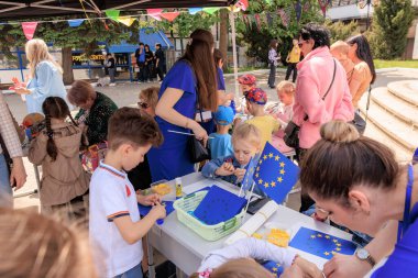 19 Mayıs 2024 'te Balti Moldova' da AB bayrakları ve el sanatları ile Avrupa Günü kutlamaları sırasında çocuklar yaratıcı faaliyetlerde bulundular.