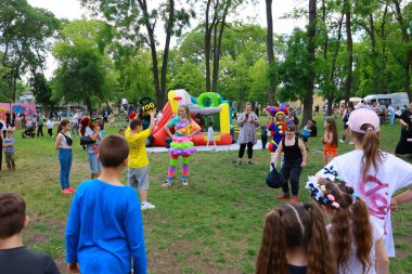 Çocuklar dışarıda palyaçolarla ve şişme şişme kutularla parkta parti yapmayı severler. 31 Mayıs 2024 Balti Moldova.