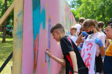 Genç Kafkas gençler açık hava yaz atölyesinde renkli duvar sanatı yapıyor. 31 Mayıs 2024 Balti Moldova.