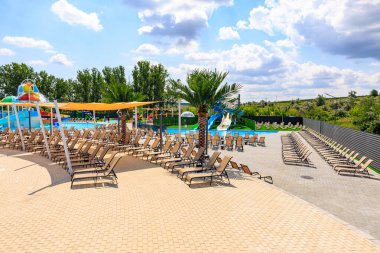 Havuzu ve bir sürü şezlongu olan bir plaj. Sandalyeler yayılmış ve bazıları boş. 8 Haziran 2024 Balti Moldova