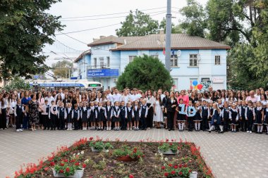 Okul çocukları ve yetişkinler açık havada toplanıyor. 2 Eylül 2024 Balti Moldova.