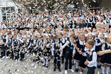 Okul kutlamalarında üniformalı ve konfeti giymiş öğrenciler var. 2 Eylül 2024 Balti Moldova.