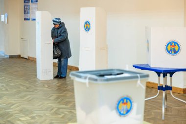 Beyaz, yaşlı kadın oy kullanma merkezindeki seçimlerde oy veriyor. 20 Ekim 2024 Balti, Moldova.