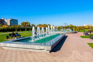 Ortasında çeşme ve etrafında birkaç bank olan bir park. Çeşme yeşildir ve içinden çok su çıkar. 27 Ekim 2024 Chisinau Moldova
