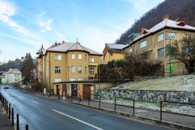 Yolun sağ tarafında binası olan bir cadde. Binanın kahverengi bir çatısı var. 14 Aralık 2024 Brasov Romanya