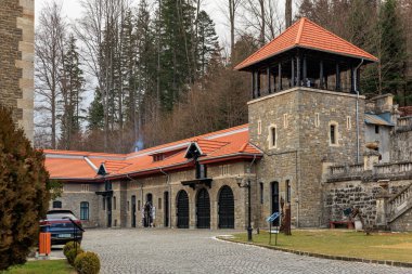 Kırmızı çatılı ve büyük kulesi olan bina, Cantacuzino Kalesi. 15 Aralık 2024 Busteni Romanya.