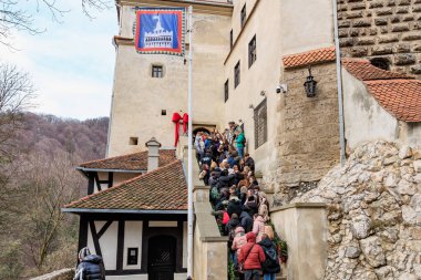 Büyük bir grup insan Kont Drakula 'nın kalesindeki taş bir merdivenden yukarı çıkıyorlar. 16 Aralık 2024 Bran Romanya.