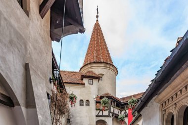 Kırmızı çatılı ve kırmızı bayraklı bina, Drakula Kalesi. 16 Aralık 2024 Bran Romanya.