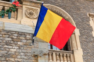 Romen bayrağı taş mimarili tarihi bina üzerine.