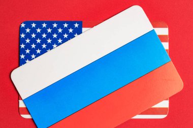 Kırmızı arkaplanda üst üste binen Rus ve Amerikan bayrakları.