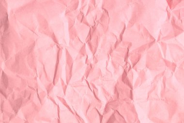 Kırışık yüzeyi ve yumuşak tonu olan buruşuk pembe kağıt dokusu.