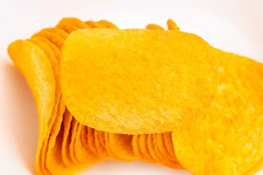 Bir tabak sarı cips. Tabakta bir sürü cips var. Çiplerin hepsi farklı boyutlarda.