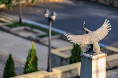 Kentsel park ortamında taş kaideye uzanan kanatları olan görkemli kartal heykeli. 13 Ekim 2024 Cimislia Moldova.