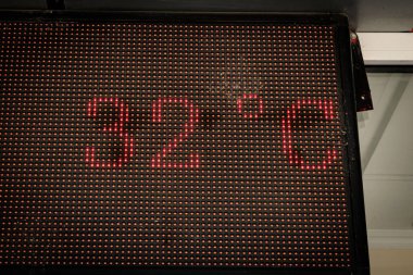 Elektronik sıcaklık göstergesi kırmızı noktalarda 32 dereceyi gösteriyor.