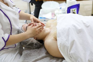 Kadın spa ortamında yüz masajı yaptırıyor. Rahatlama ve cilt bakımı için. 30 Nisan 2024 Balti Moldova.